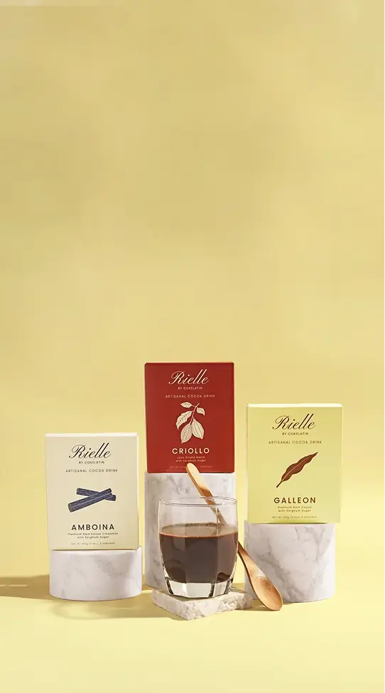 Rielle cocoa mixes displayed with a prepared cup of cocoa